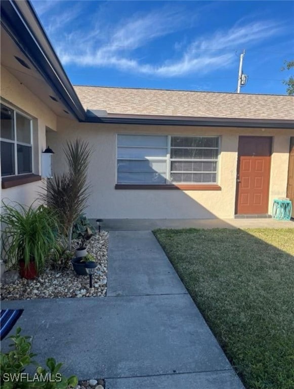 Entrance to property featuring stucco siding, a sh