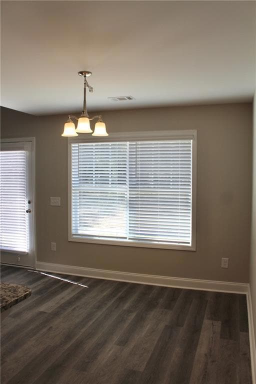 Unfurnished dining area with plenty of natural light and dark wood-style floors