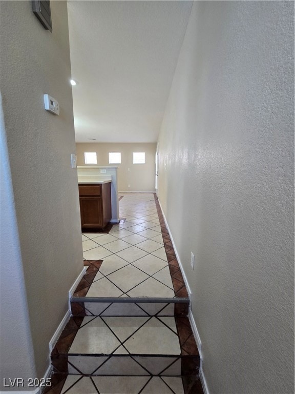 Hall featuring light tile patterned floors, basebo
