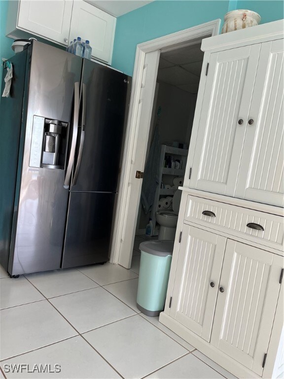 Kitchen featuring white cabinetry, refrigerator, a