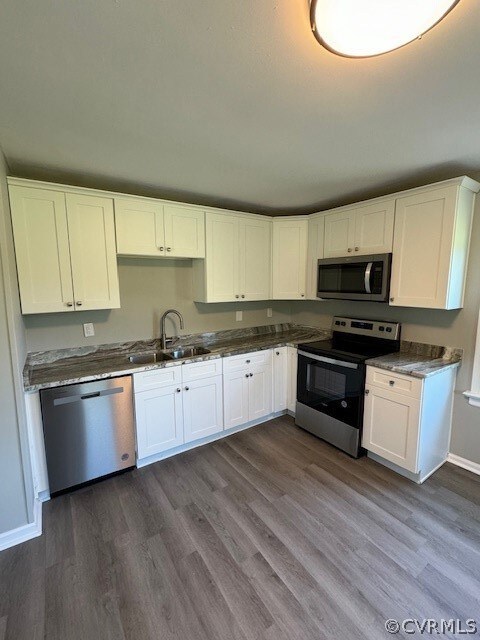 Kitchen with white cabinets, stove, dark wood-type