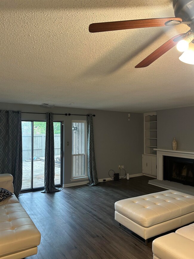 Living room with a textured ceiling, a fireplace w