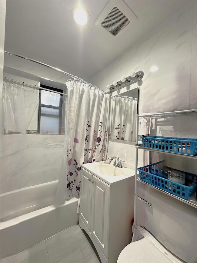 Bathroom featuring shower / bath combo, visible vents, toilet, tile patterned floors, and vanity
