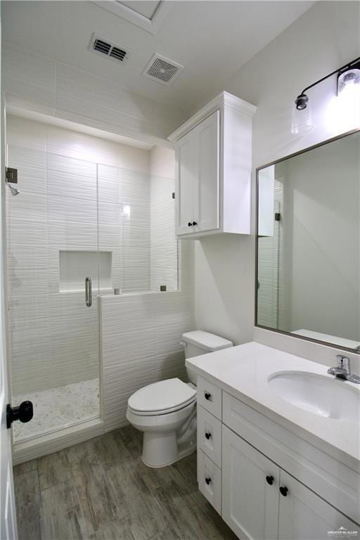 Bathroom featuring vanity, a stall shower, and dark wood-style floors