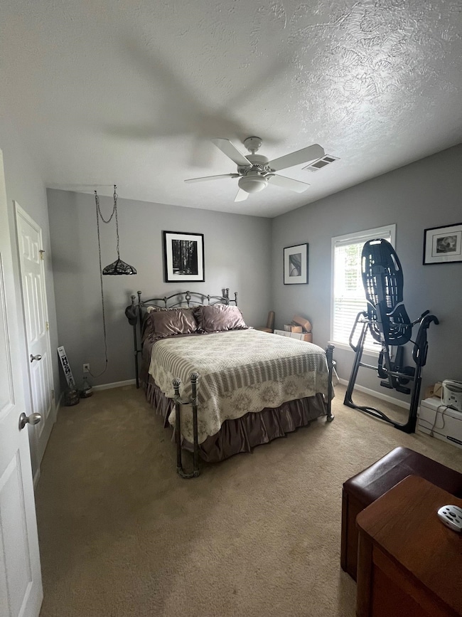 Carpeted bedroom featuring a textured ceiling and 