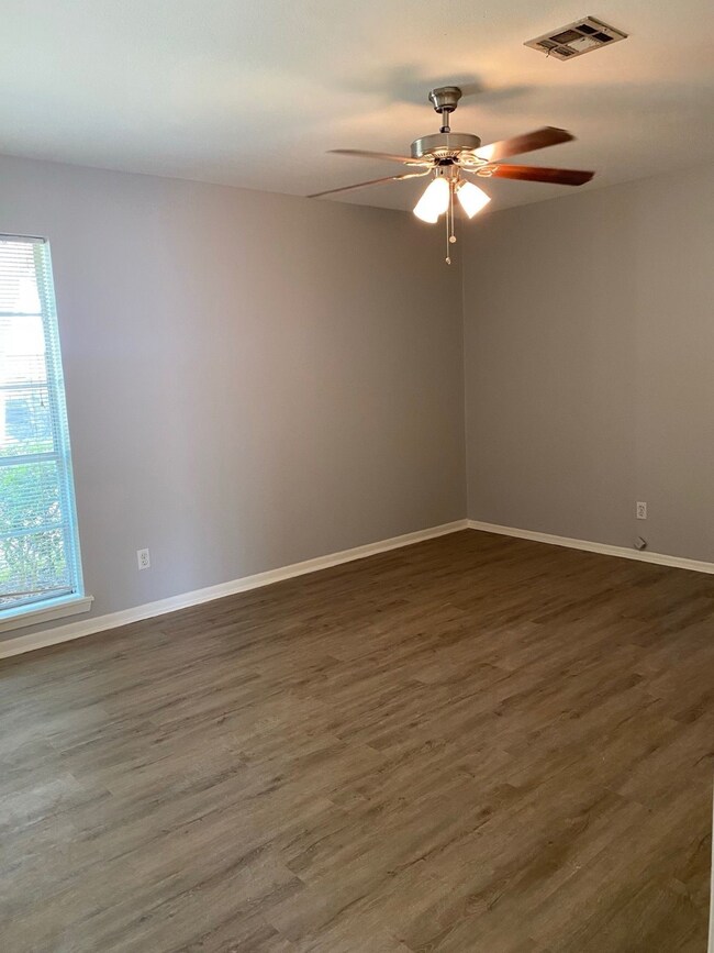 Primary room with light gray walls and wood-look f