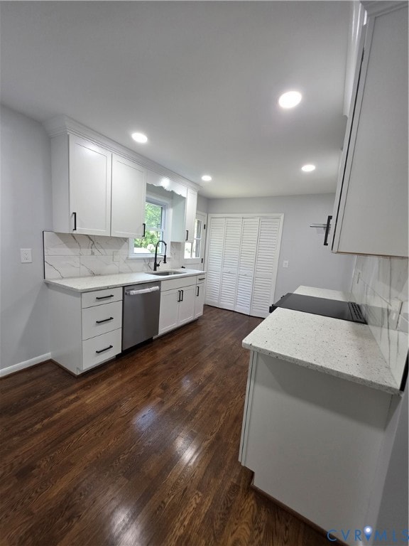 Kitchen with light stone countertops, backsplash, white cabinets, and recessed lighting