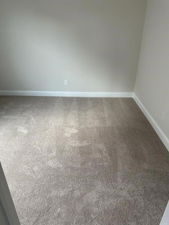 Empty room with carpet floors and baseboards