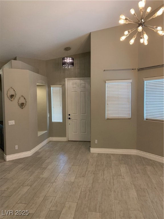 Entrance foyer with a chandelier and light wood-type flooring