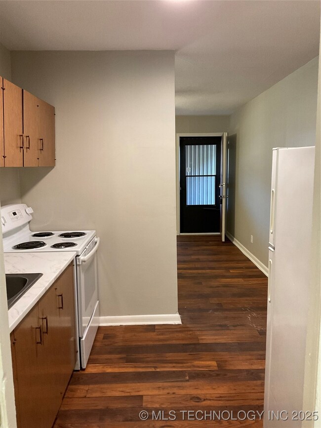 Kitchen featuring stove, dark wood finished floors