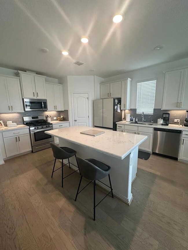 Kitchen featuring a sink, backsplash, a kitchen b