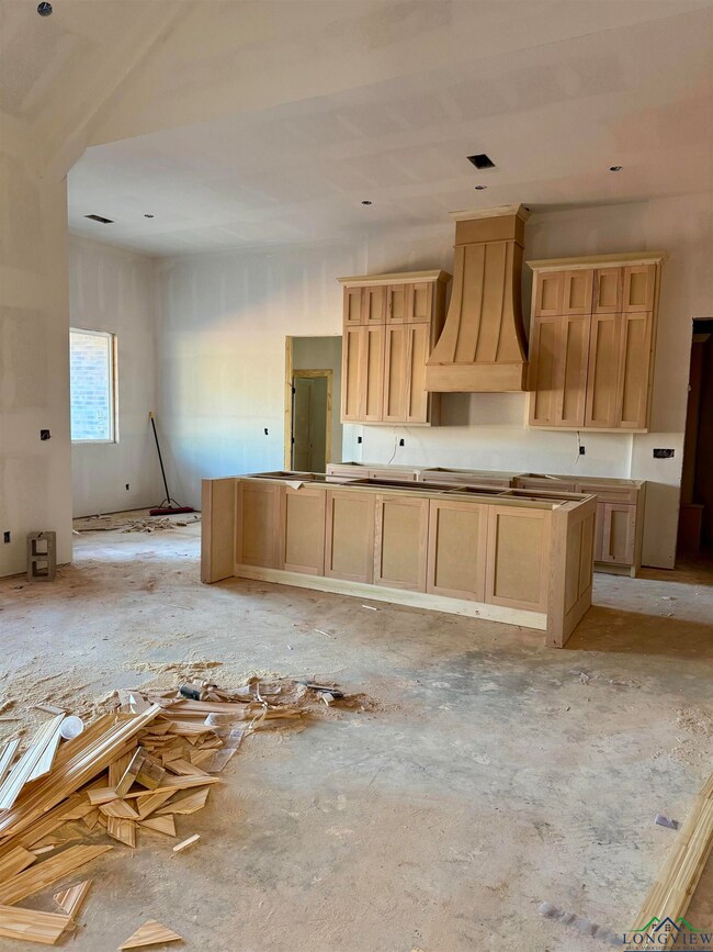 Kitchen featuring light brown cabinetry and custom exhaust hood