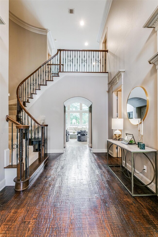 Foyer with ornamental molding, a high ceiling, and hardwood / wood-style flooring