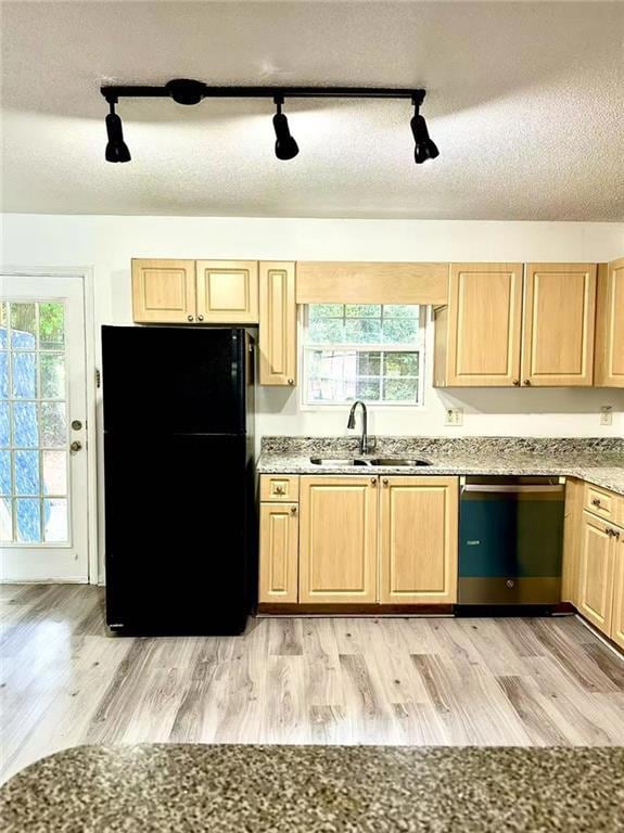 Kitchen featuring freestanding refrigerator, rail lighting, light brown cabinetry, dishwasher, and a textured ceiling