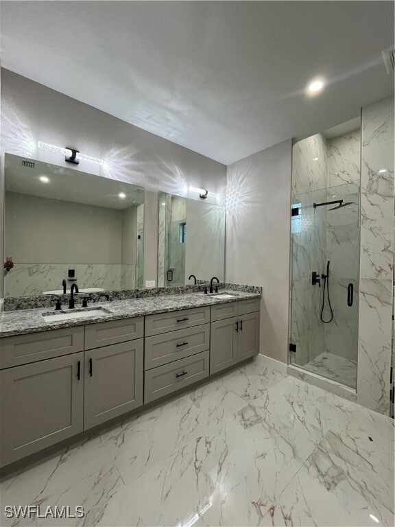 Bathroom featuring vanity and a shower with shower