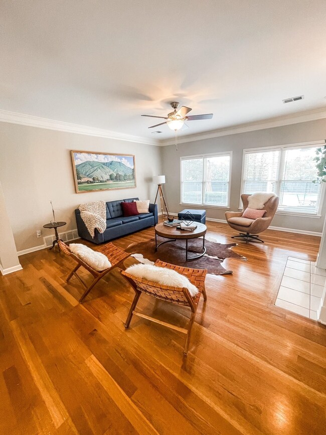 Living room featuring hardwood / wood-style floors, plenty of natural light, and ornamental molding