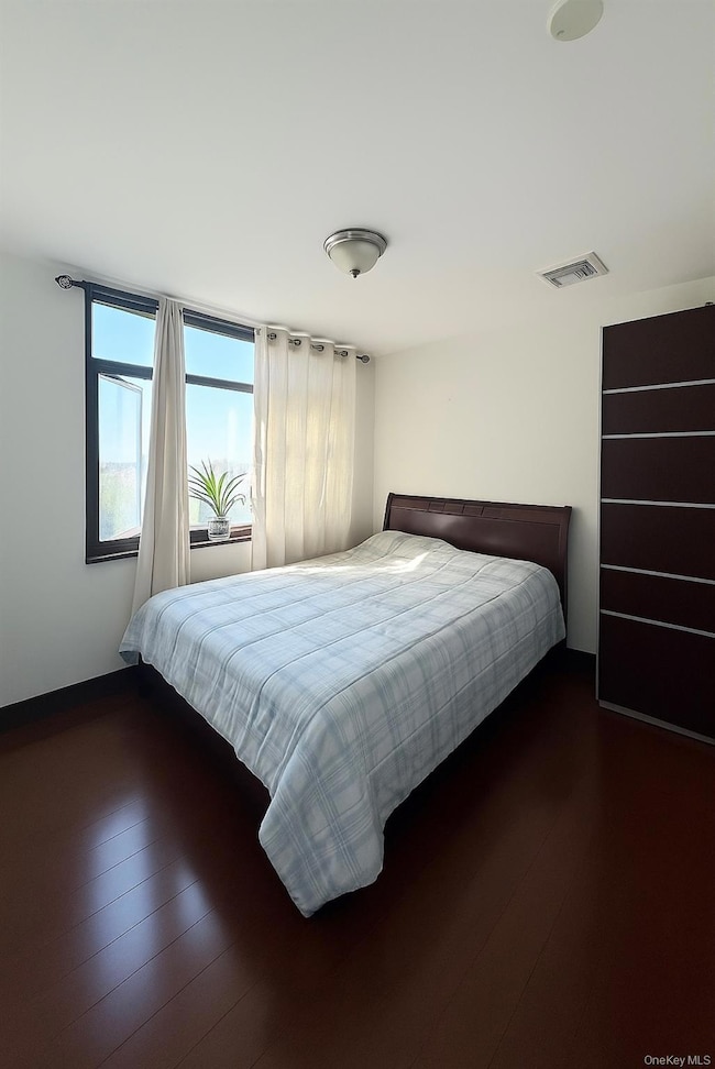 Bedroom with wood finished floors and baseboards