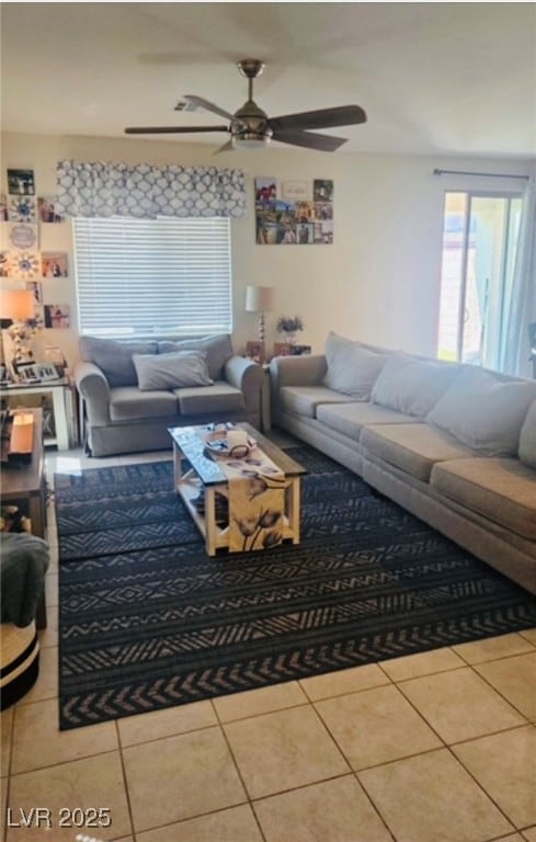 Living room featuring a ceiling fan and tile patte