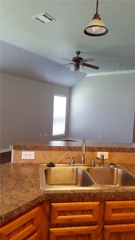 Kitchen featuring a ceiling fan, dark countertops,