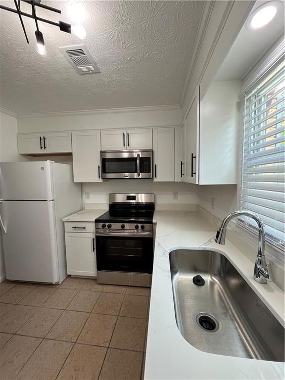 Kitchen featuring visible vents, range, refrigerat