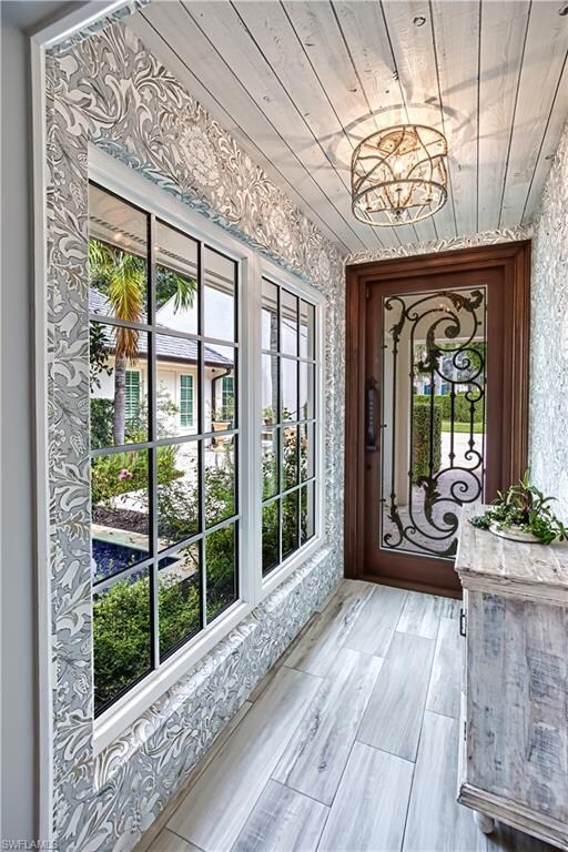Foyer entrance featuring a notable chandelier, lig