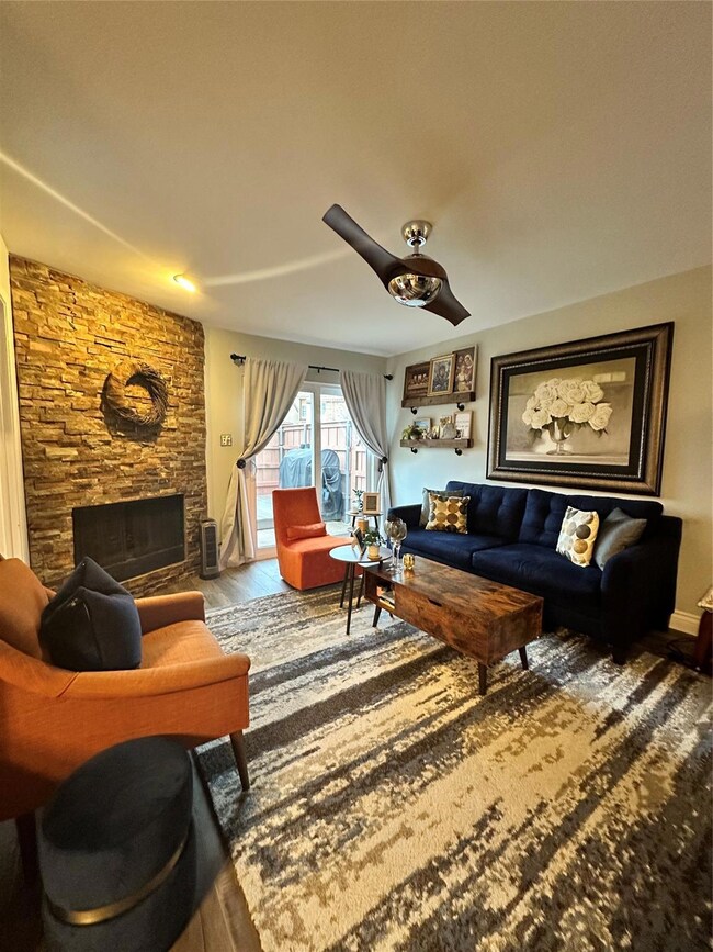 Living area featuring a stone fireplace and wood f