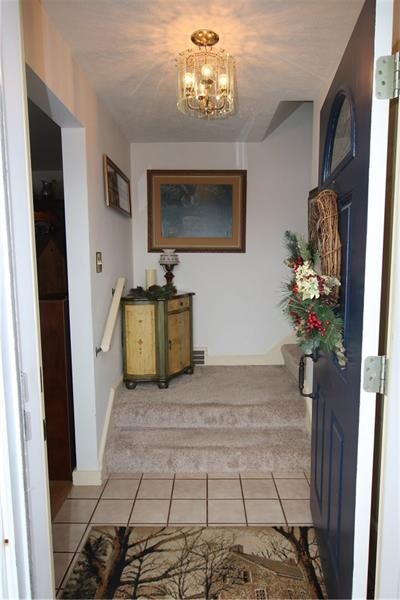 Ceramic front entry hall with stairs leading to th
