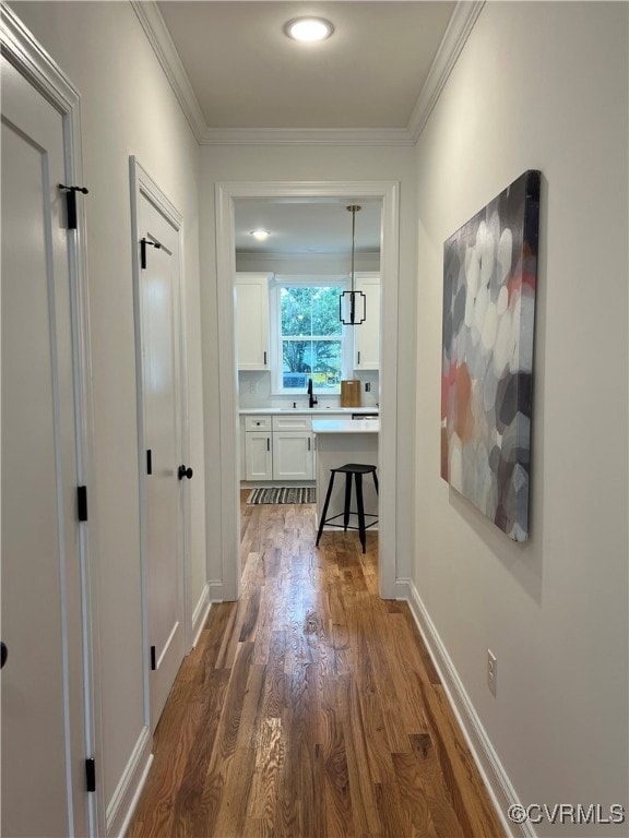 Hall with dark wood-type flooring, crown molding,