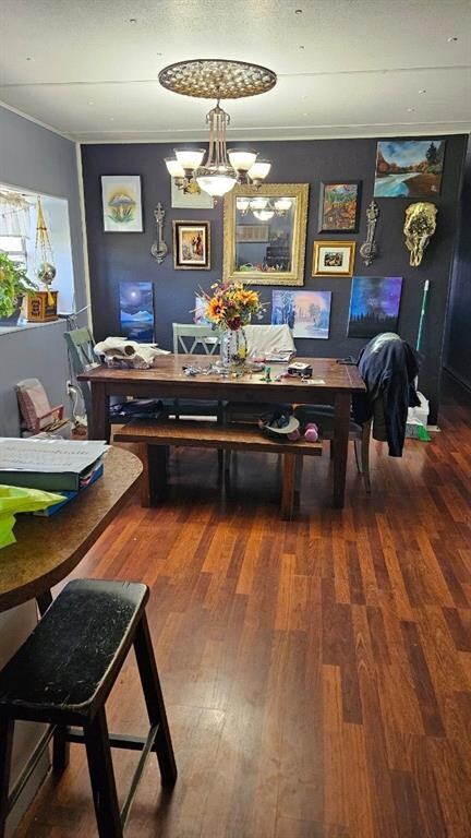 Dining space with an inviting chandelier and dark wood-type flooring