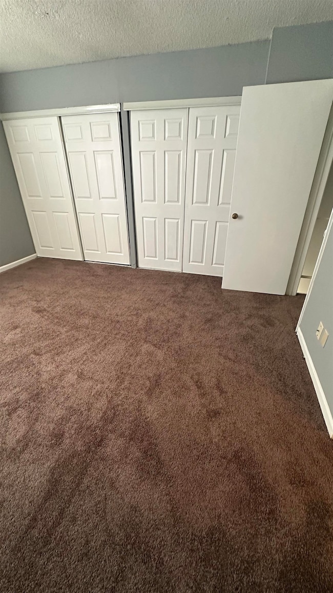Unfurnished bedroom with a textured ceiling and ca