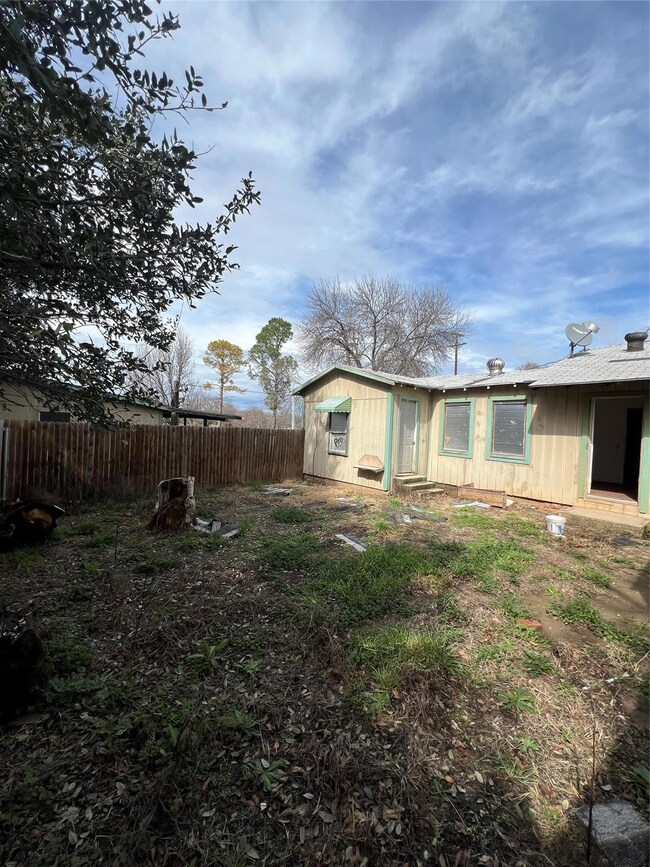 Back yard with privacy fence. Primary bedroom door