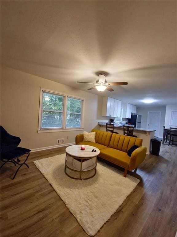 Living room featuring visible vents, ceiling fan, 