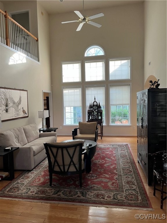 Living area with a high ceiling, a ceiling fan, an