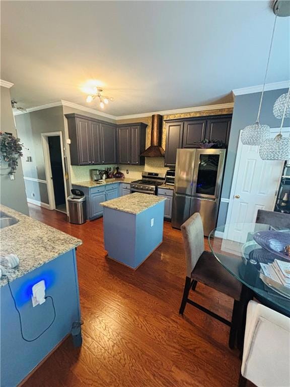 Kitchen featuring appliances with stainless steel finishes, custom exhaust hood, a kitchen island, crown molding, and dark wood finished floors