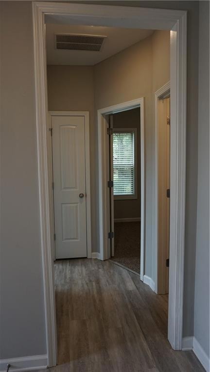 Hallway featuring baseboards and dark wood finished floors