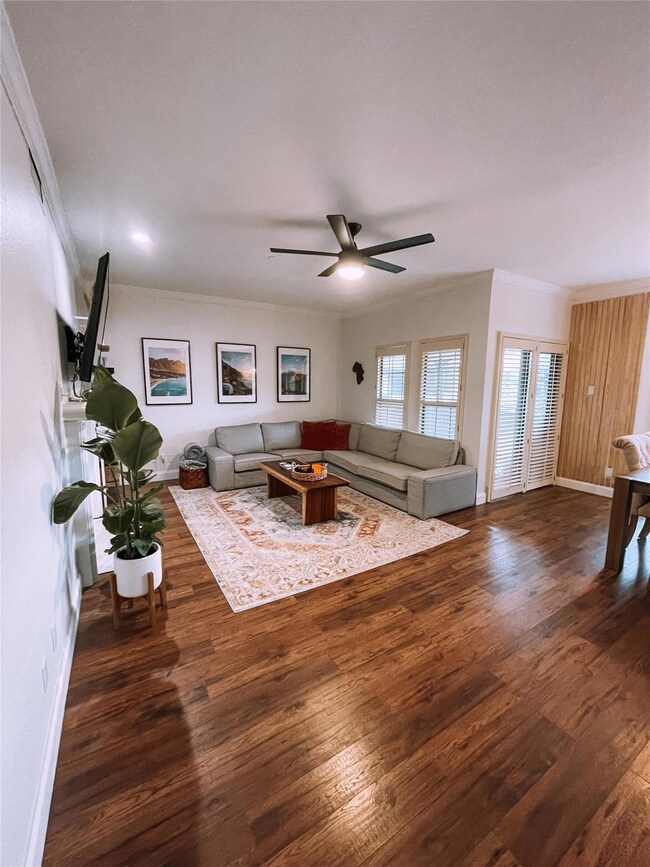 Living room with ceiling fan, ornamental molding, 