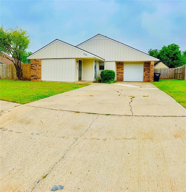 View of front of home with concrete driveway, brick siding, and an attached garage