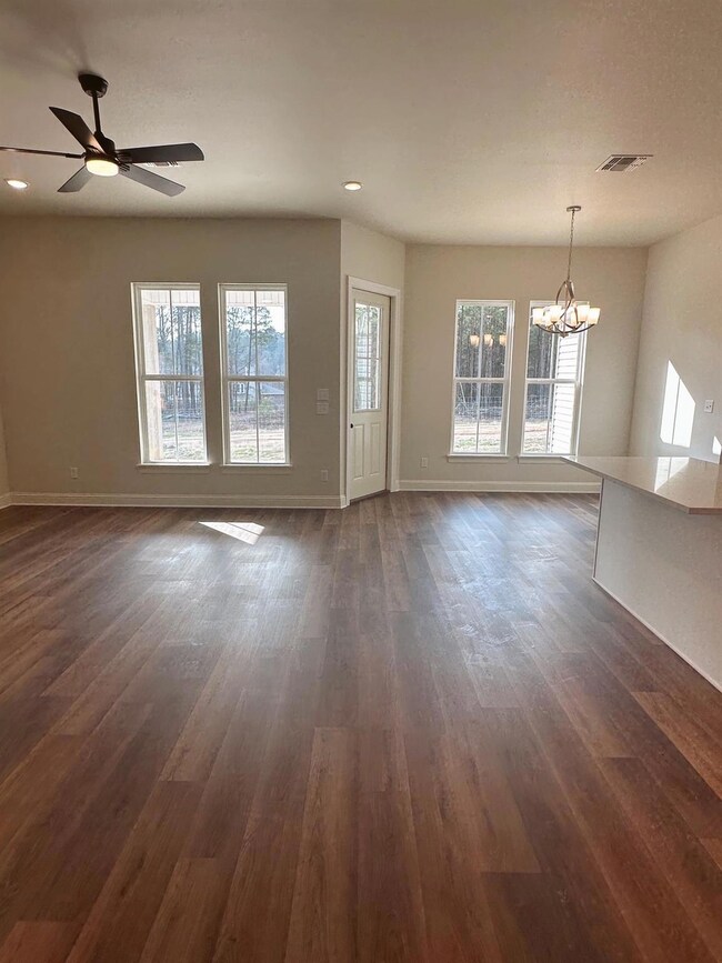 Unfurnished living room featuring dark hardwood / 