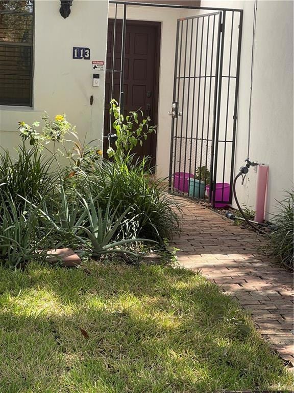 Doorway to property with a gate and stucco siding