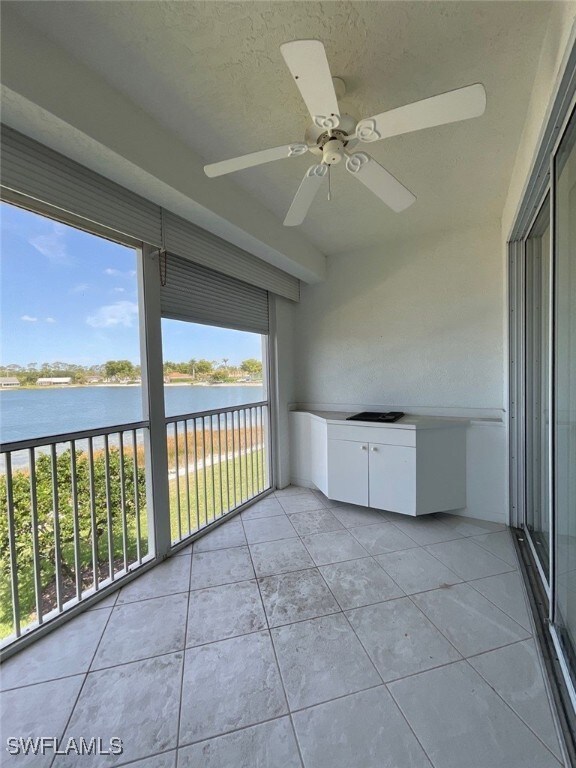 Balcony with a water view and a ceiling fan
