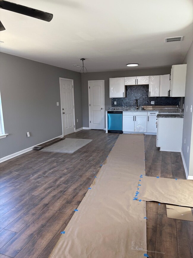 Kitchen with white cabinetry, dishwasher, sink, de