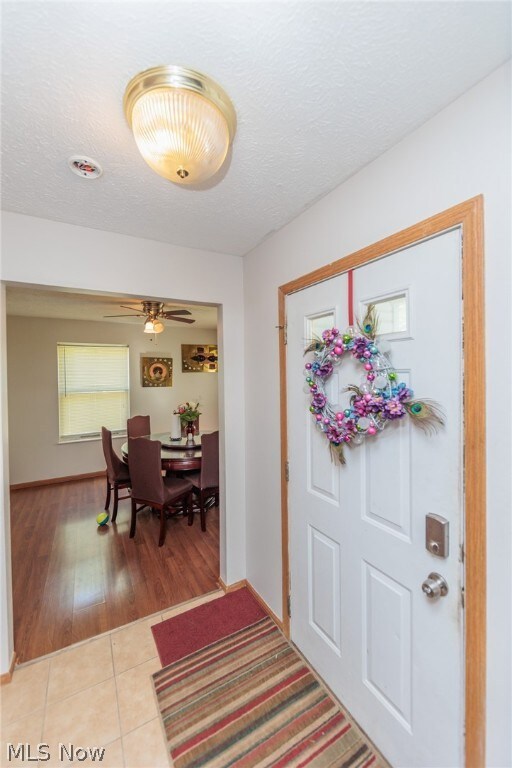 Foyer with hardwood / wood-style floors, ceiling fan, and a textured ceiling