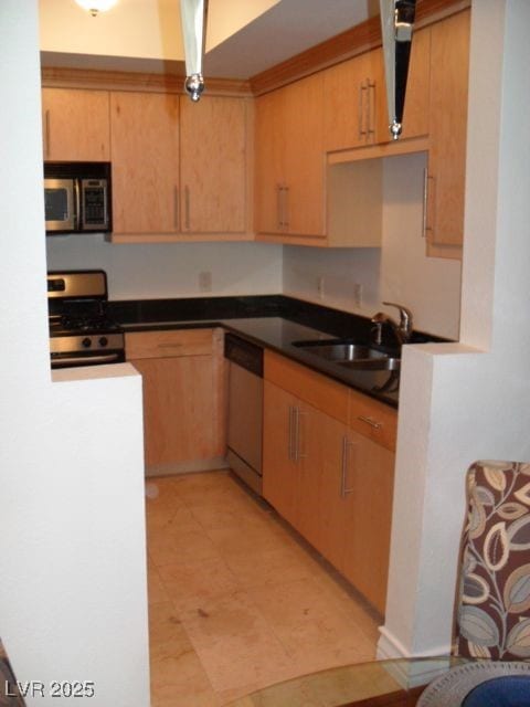 Kitchen with a sink, dark countertops, and stainle