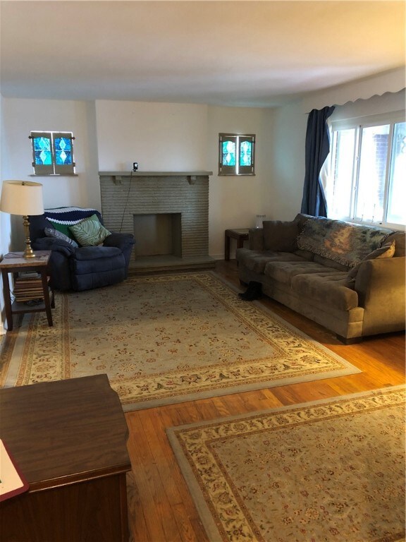 Living room view of fireplace and hard wood floors.