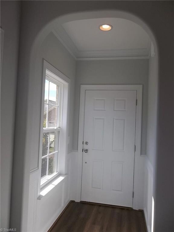 The foyer has hardwood flooring, wainscoting, double crown molding, recessed lighting, archway leading into great room and lots of natural light.
