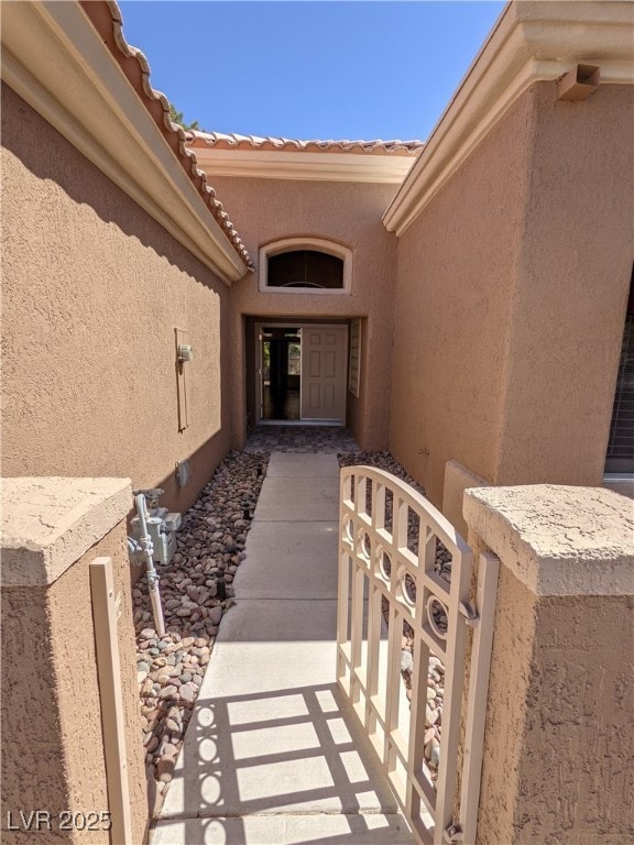 View of exterior entry with stucco siding and a ga
