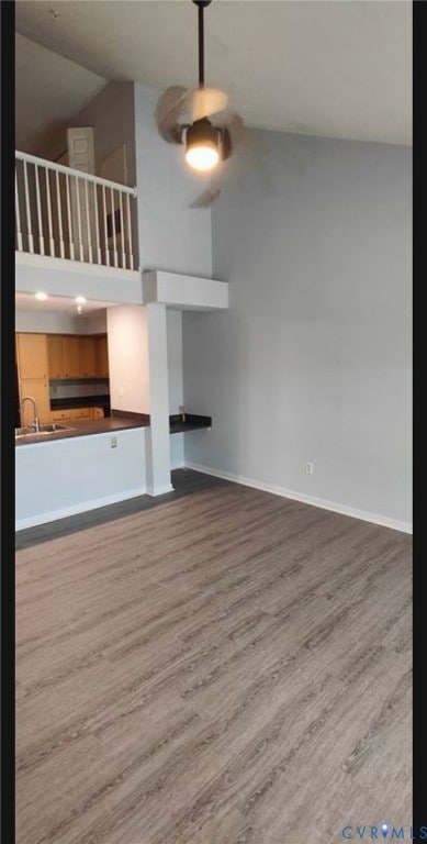 Unfurnished living room featuring dark wood-style floors and high vaulted ceiling
