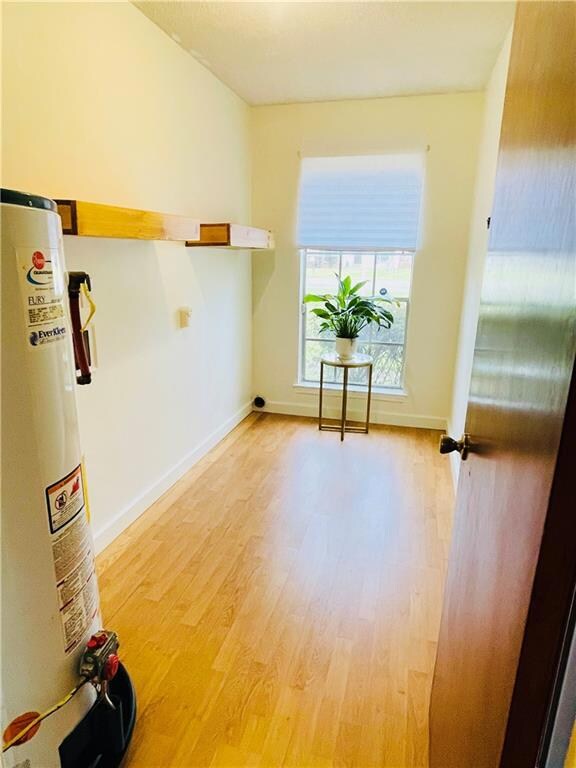 Spare room featuring baseboards, water heater, and