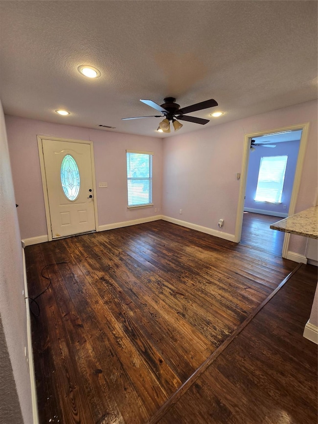 Entryway with ceiling fan, a textured ceiling, and