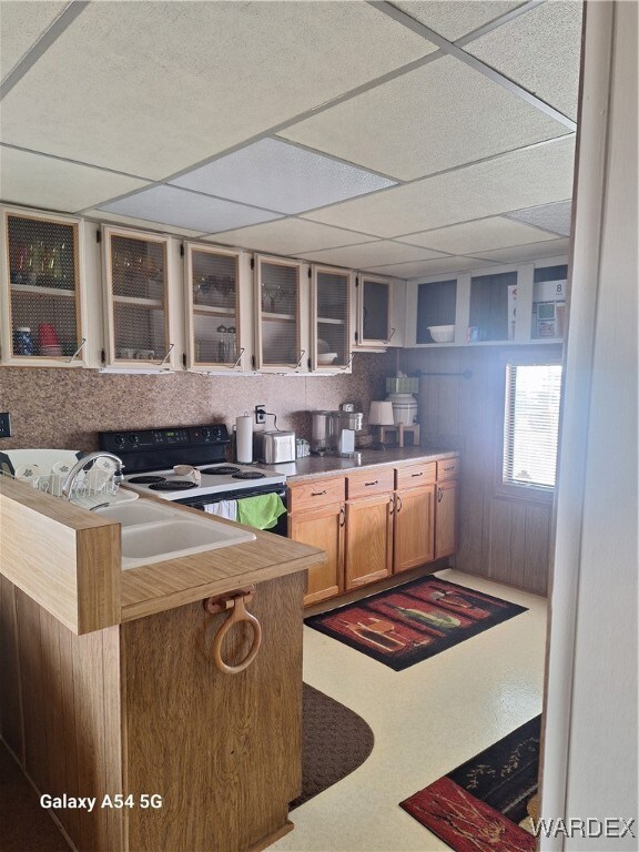 Kitchen featuring glass insert cabinets, a drop ce